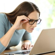 woman squinting to see computer screen