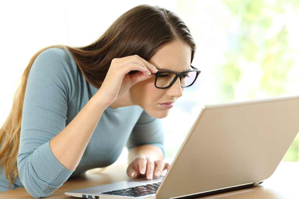 woman squinting to see computer screen