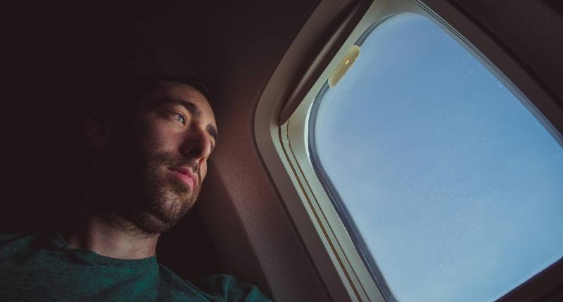 man on a plane looking out the window