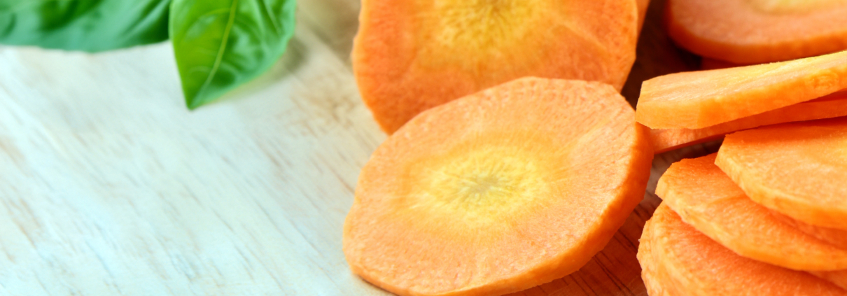Close-up of freshly sliced carrot rounds on a wooden cutting board