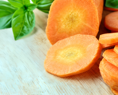 Close-up of freshly sliced carrot rounds on a wooden cutting board